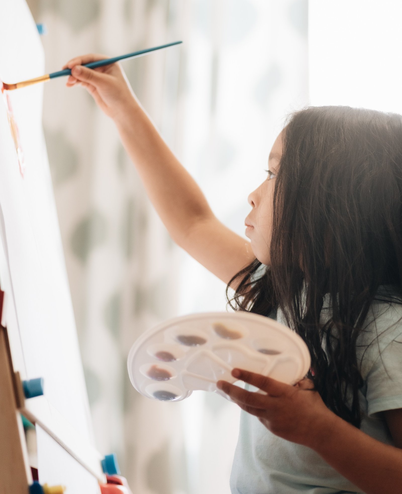 diverse pre school aged girl at home painting for fun and leisure